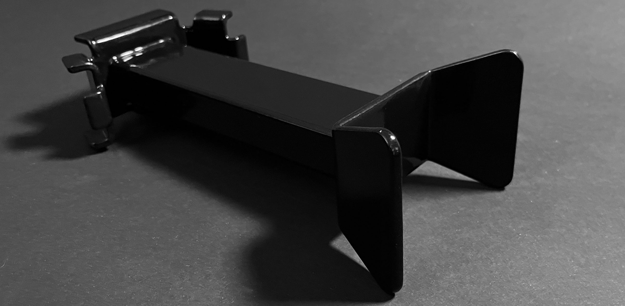 Studio photo on a dark grey background of a Bed Buddy Offset Wheel Chock.