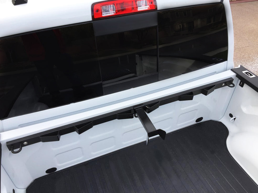 An above view looking down at a CCR Sport Bed Buddy Moto Rack with an Offset Wheel Chock installed in the bed of a white truck.