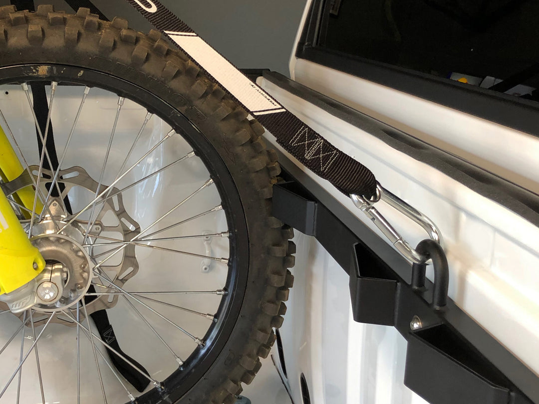 A tight shot of a dirt bike tire held in place by the CCR Sport Bed Buddy Moto Rack.