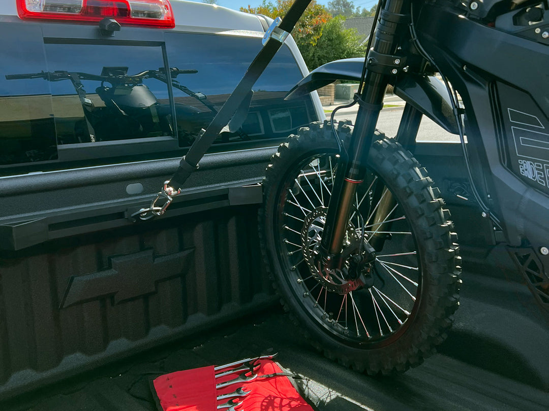 An electric dirt bike secured to the Hybrid Moto Rack in the bed of a truck.