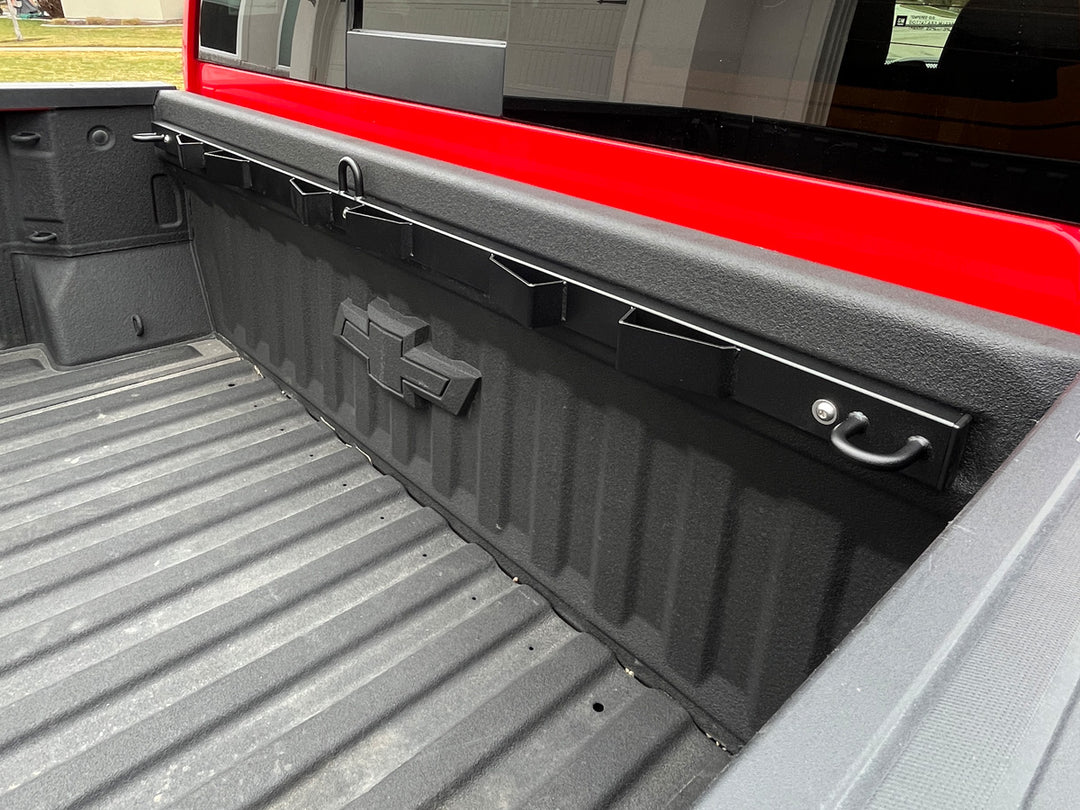 A side view of the Bed Buddy Moto Rack mounted to the front bed bulkhead of a Chevy Silverado pickup.