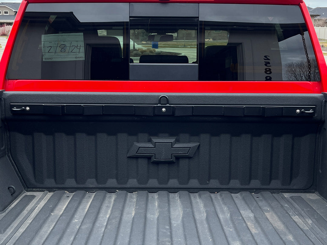 A clean install of the CCR Sport Bed Buddy Moto Rack in the bed of a red Chevrolet Silverado truck bed.