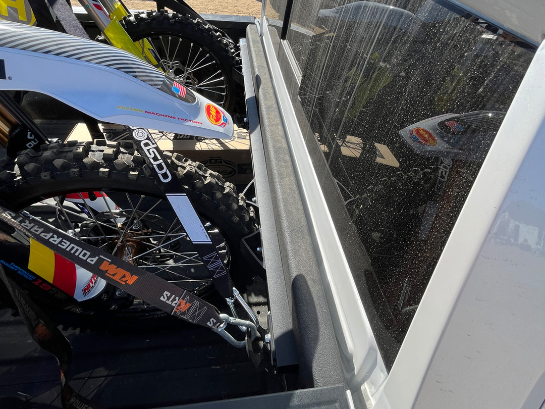 A side angle of the CCR Sport Hybrid Moto Rack in a Chevrolet Silverado truck with two motocross bikes tied down for transport.