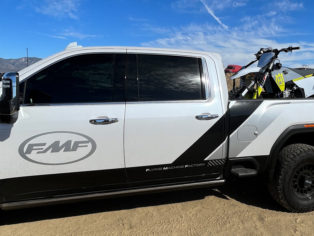 The FMF Racing Chevrolet Silverado with a Husqvarna motorcycle tie down in the truck bed.