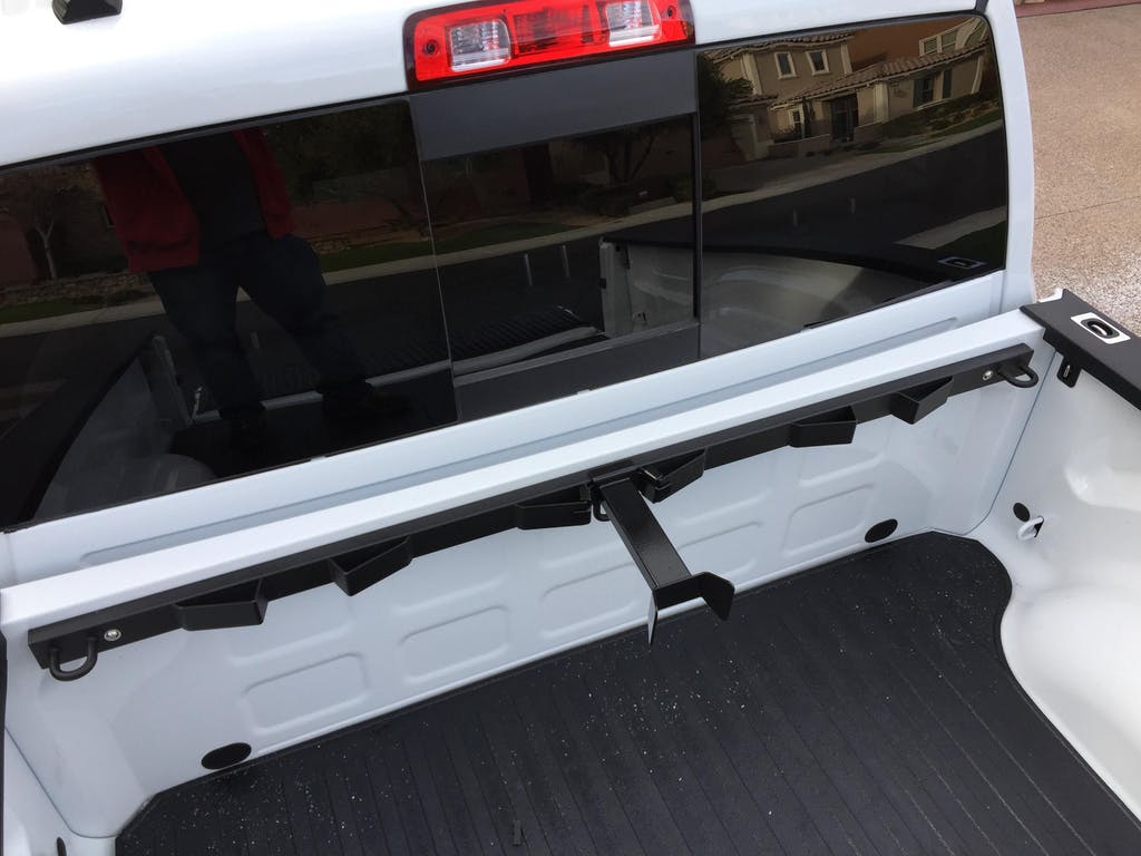 The Bed Buddy Motorcycle Tie Down Truck Rack mounted in a white Dodge Ram shown with the Offset Wheel Chock installed.