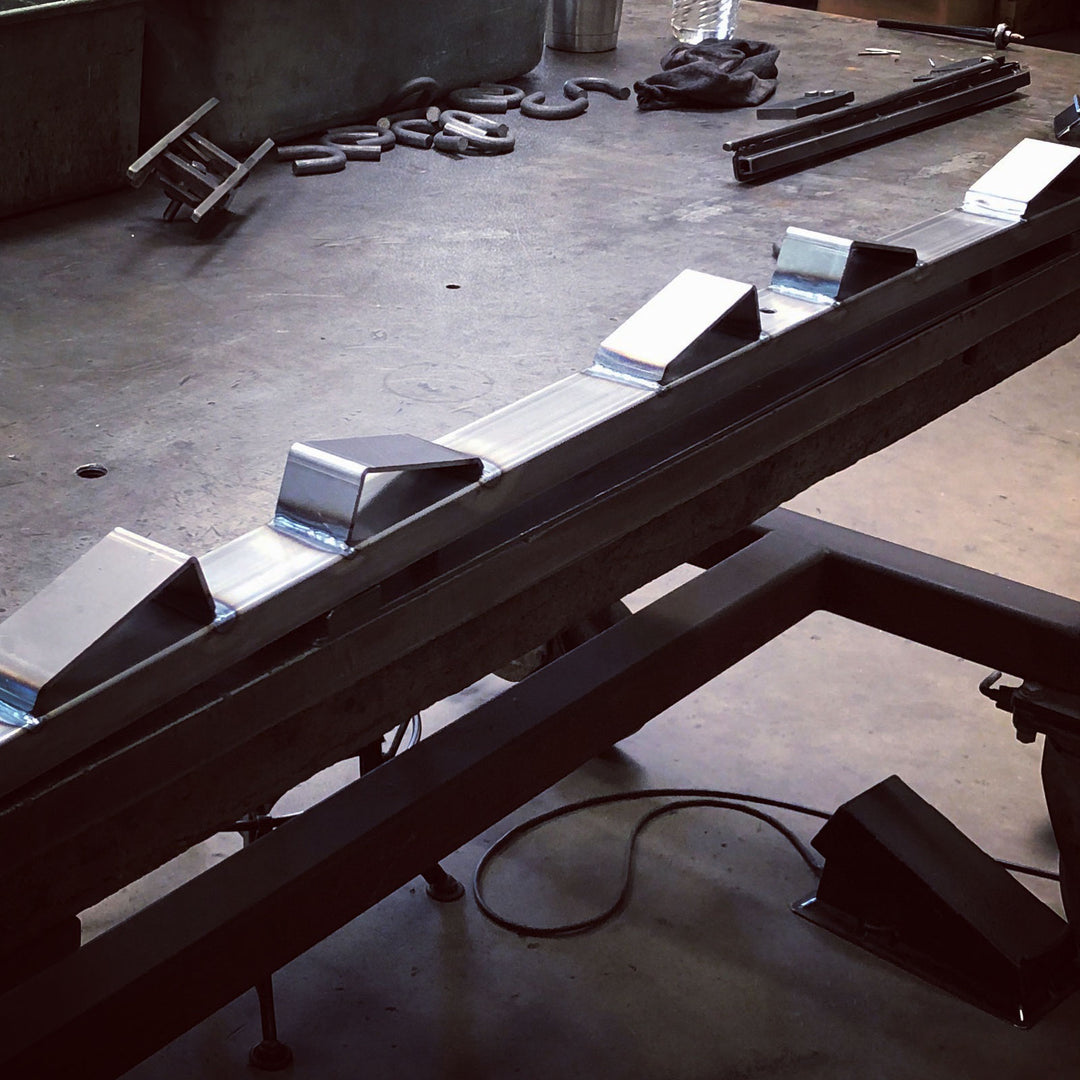 An image of a Bed Buddy Moto Rack on a fabrication table in a shop setting.