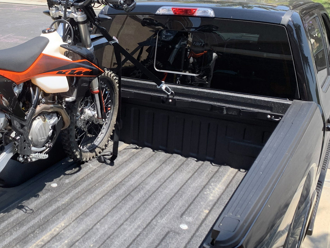 The Bed Buddy motorycle tie down rack featured in the bed of a Ford F150 with a single motorcycle tied down for transport.