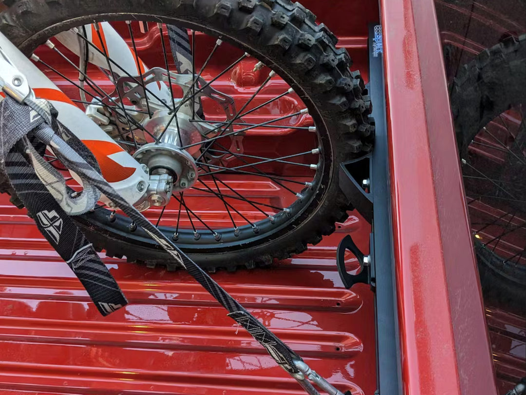 Detailed view of the Hybrid Moto Rack with the Moto Vise Wheel Chock stabilizing the front tire of a dirt bike in a Ford Maverick.