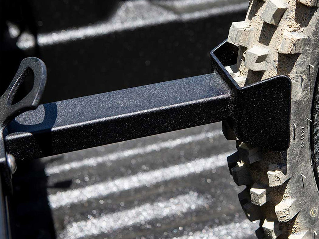 A close-up detailed image of the Hybrid Offset Wheel Chock with a knobby dirt bike tire.