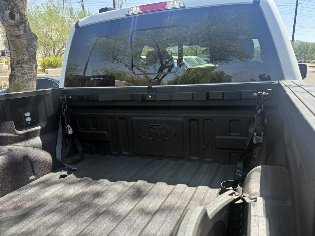 A Bed Buddy Moto Rack installed in the bed of a Ford Super Duty truck with tie-down straps.