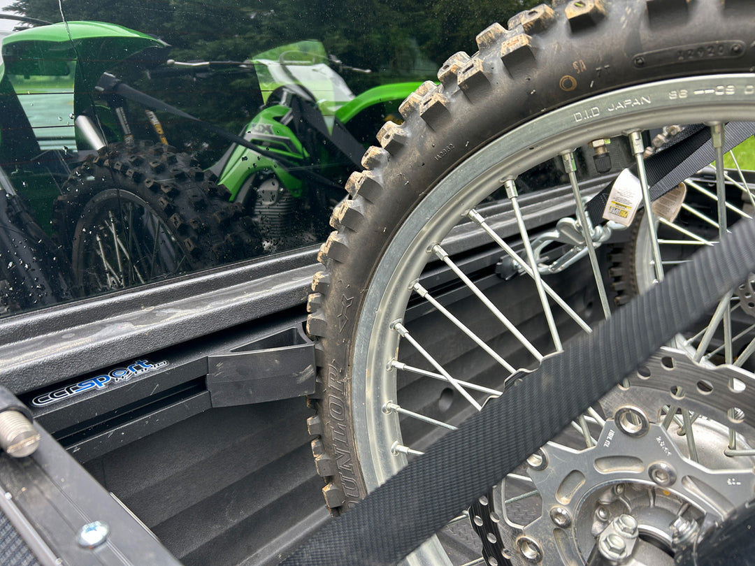 Off-road motorcycle secured in a Honda Ridgeline truck bed using a CCR Sport motorcycle transport system.