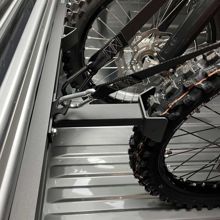 Hybrid Offset Wheel Chock offsetting a motorcycle or transport in a truck bed.