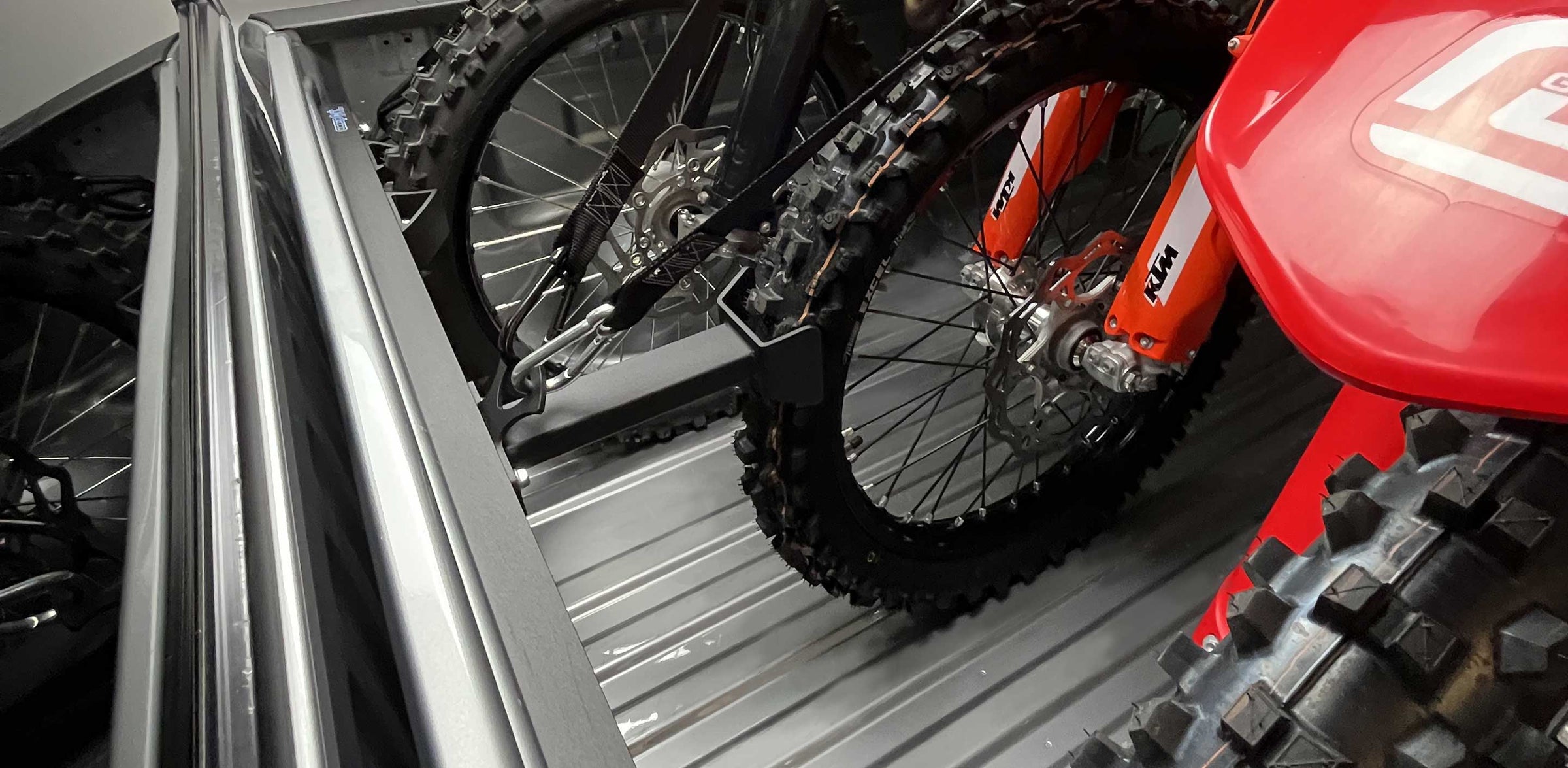 Close-up of the Hybrid Offset Wheel Chock with three dirt bikes.
