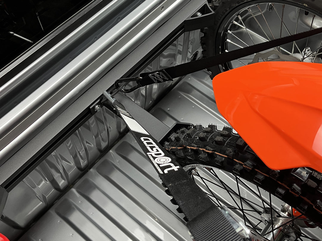 Above view of the Hybrid Offset Wheel Chock with tie down straps securing a KTM motorcycle.