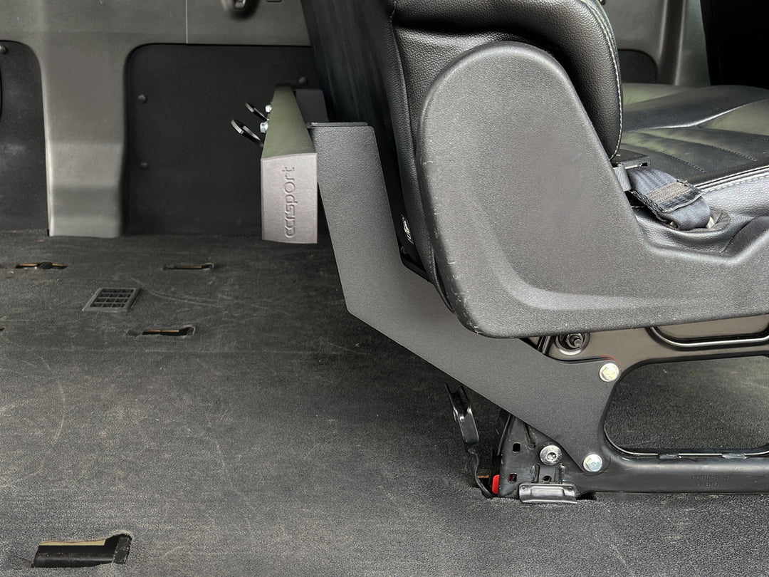 Close-up side view of the Hybrid Rack system mounted to the rear passenger seat base of a van.