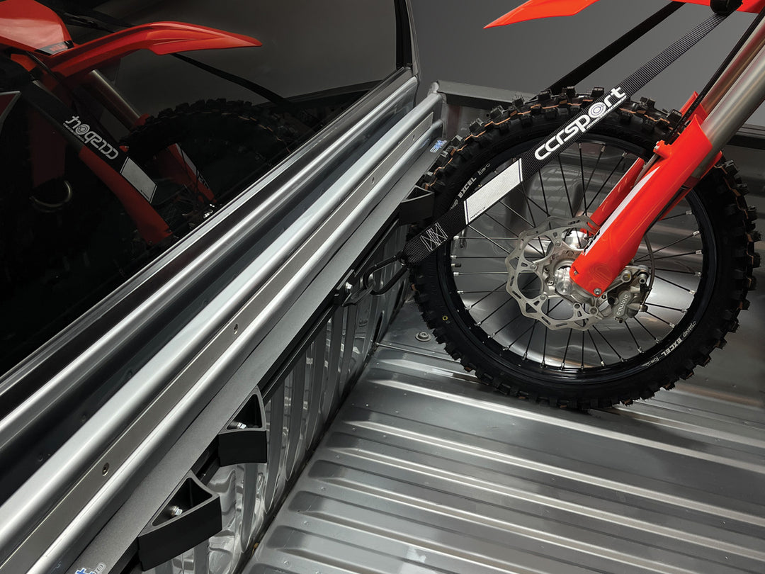 Hybrid Moto Rack mounted in the bed of a silver truck with a single motocross motorcycle tied down to the rack.