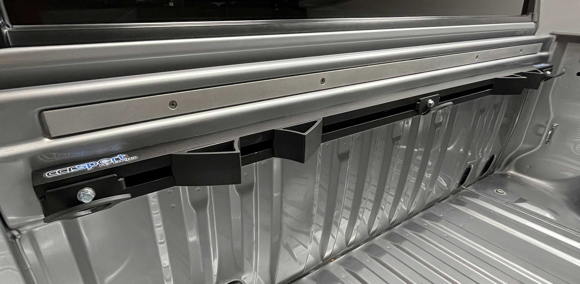 Full width image of the CCR Sport Hybrid Moto Rack mounted cleanly to a truck bed.