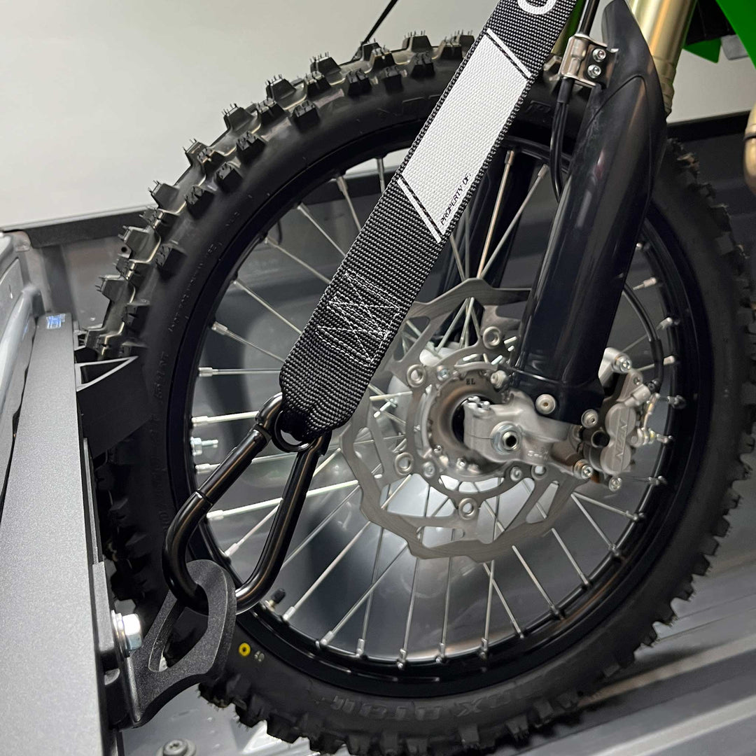 Close-up of a dirt bike tire securely supported by the width adjustable Hybrid Moto Vise wheel chock.