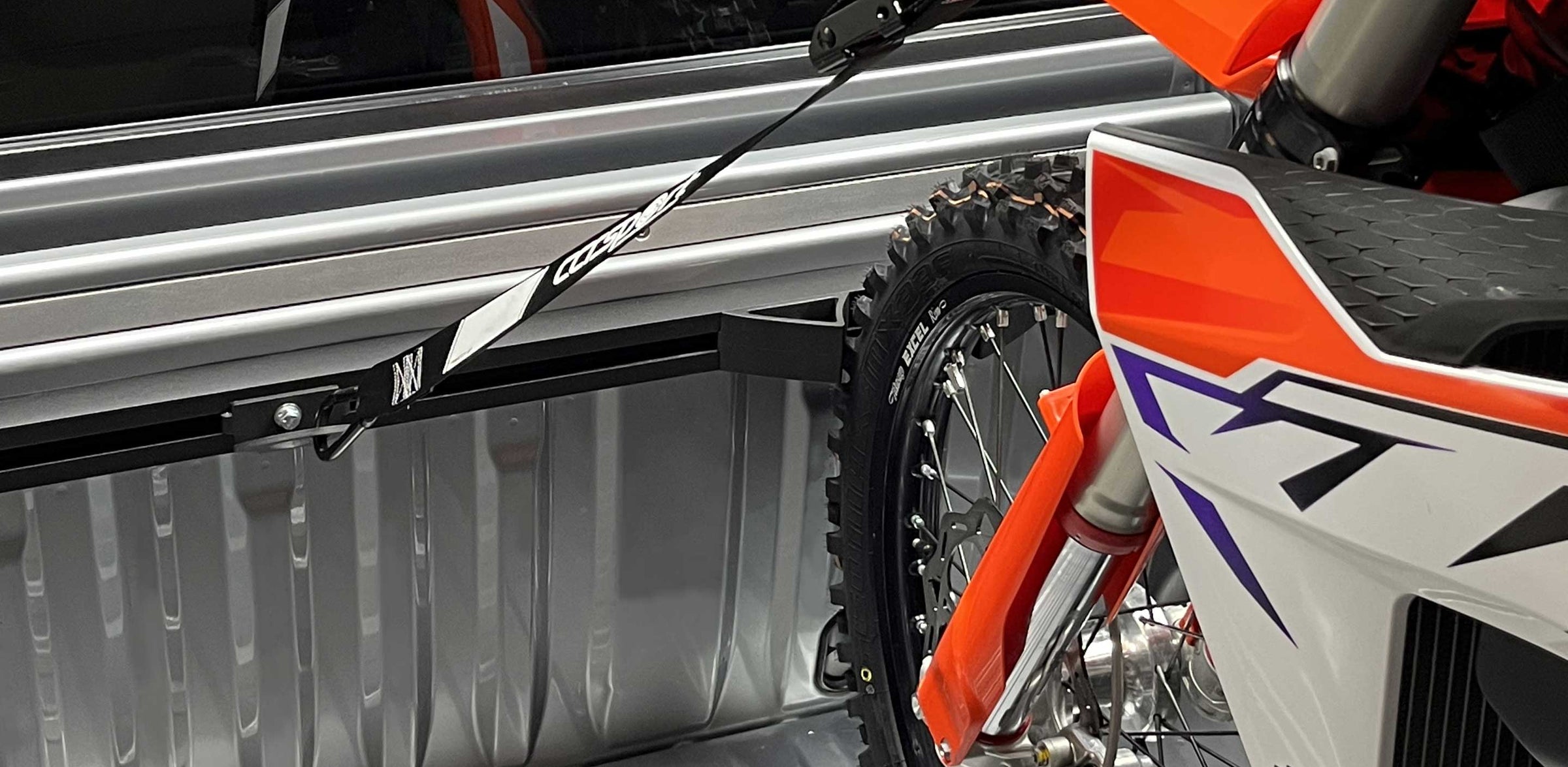 KTM motorcycle being loaded into a truck bed with a focus on the tire and front wheel.