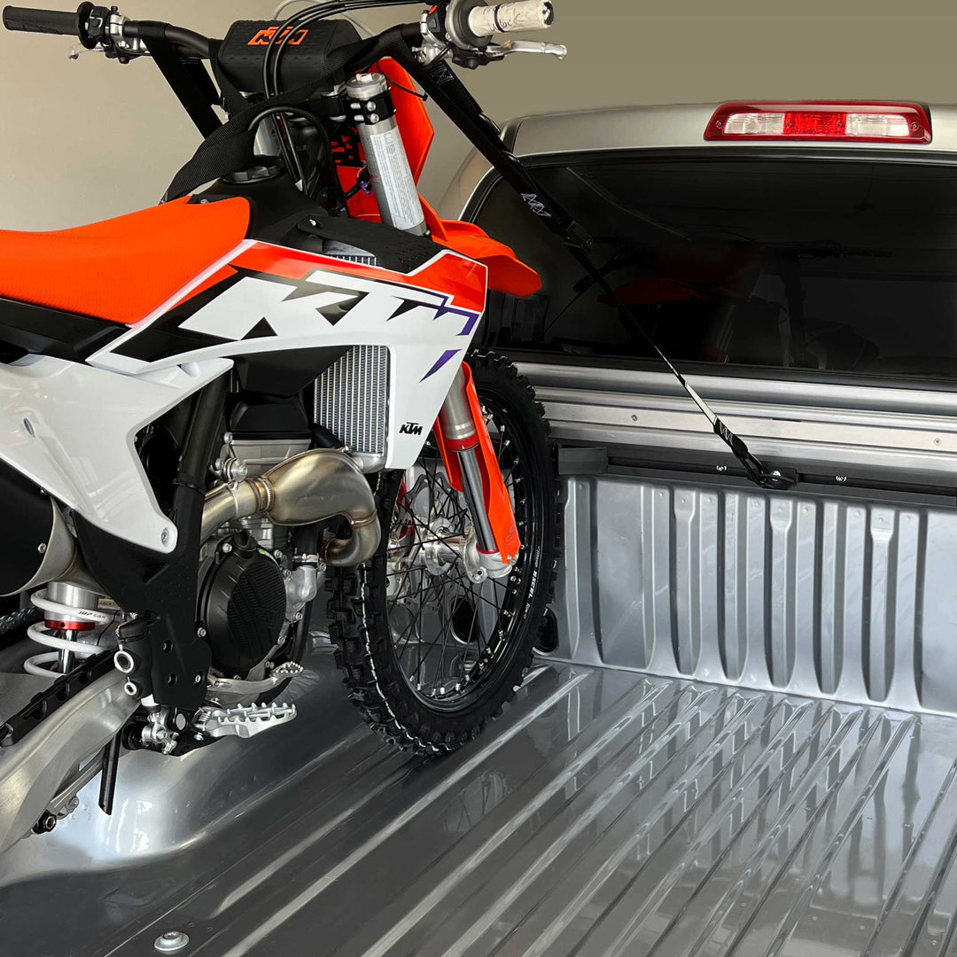 A photo of a KTM 450 dirt bike strapped securely in the bed of a truck with the Hybrid 1-Bike Pro Pack system.