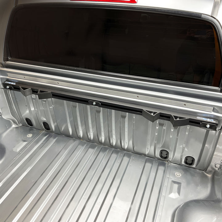 The Hybrid Moto 2 Bike rack installed in a pickup truck bed, securely mounted to the trucks bulkhead.