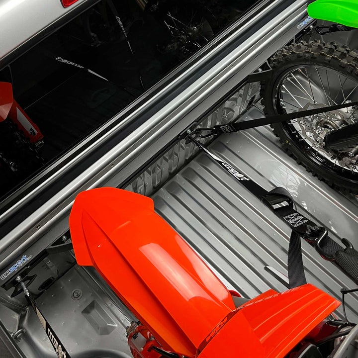 An image illustrating the advantage of the center tie down anchor on the Hybrid Moto Rack when hauling two motorcycles. 
