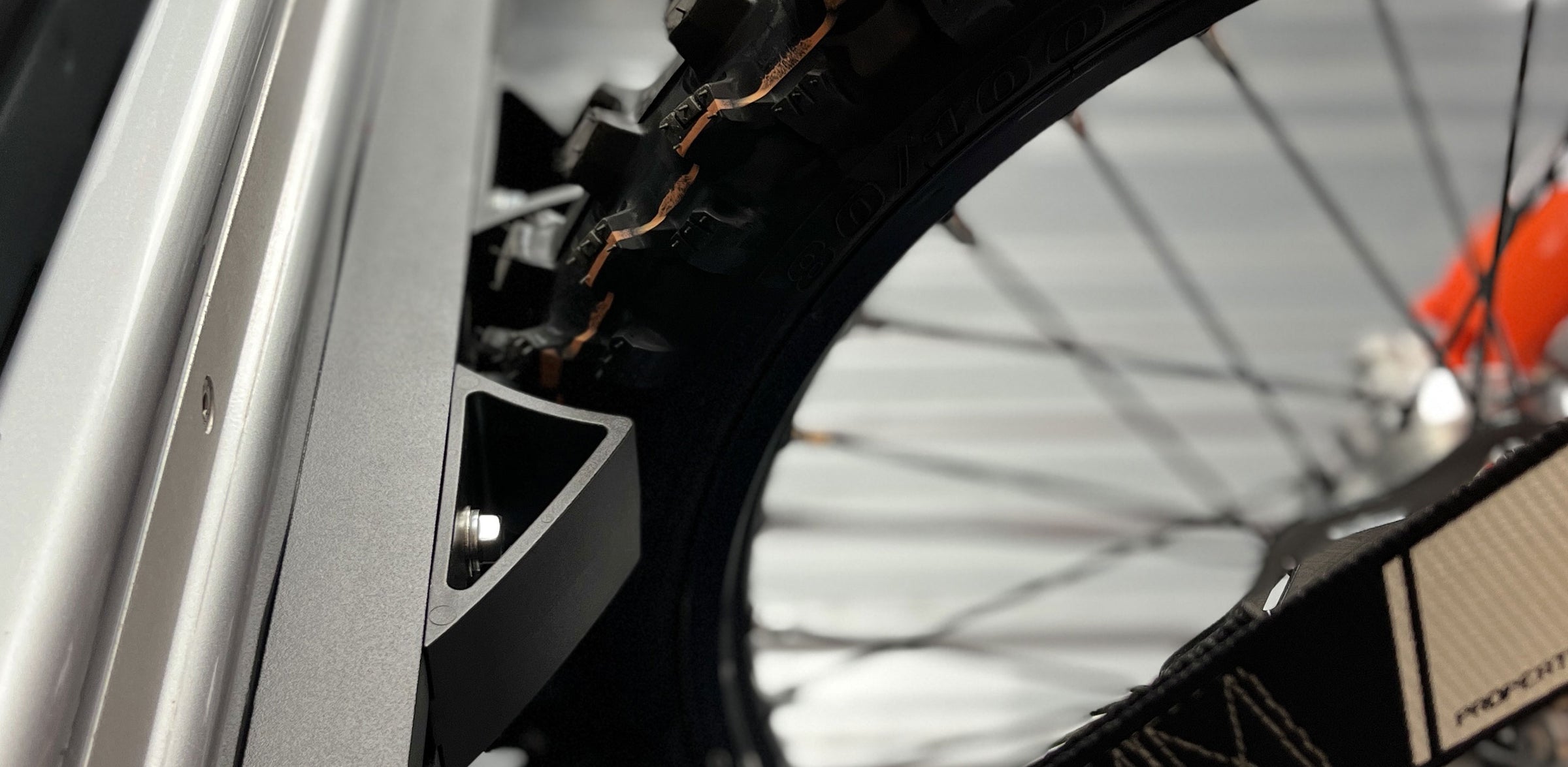 Close-up side view of a dirt bike tire stabilized in a wheel chock.