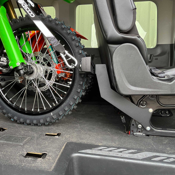 Side view of the seat base mounted Hybrid Moto Rack in a Ford Transit van.