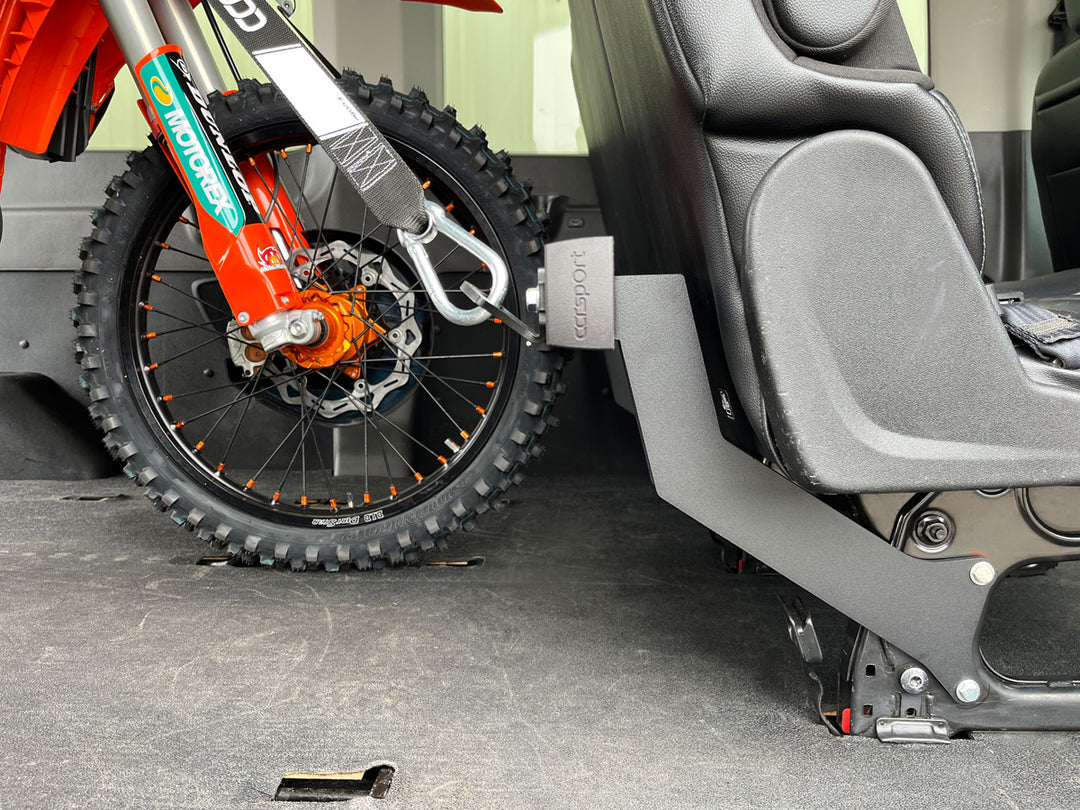 Close-up side view of the Hybrid Moto Van Rack with a dirt bike secured for transport inside of a van.