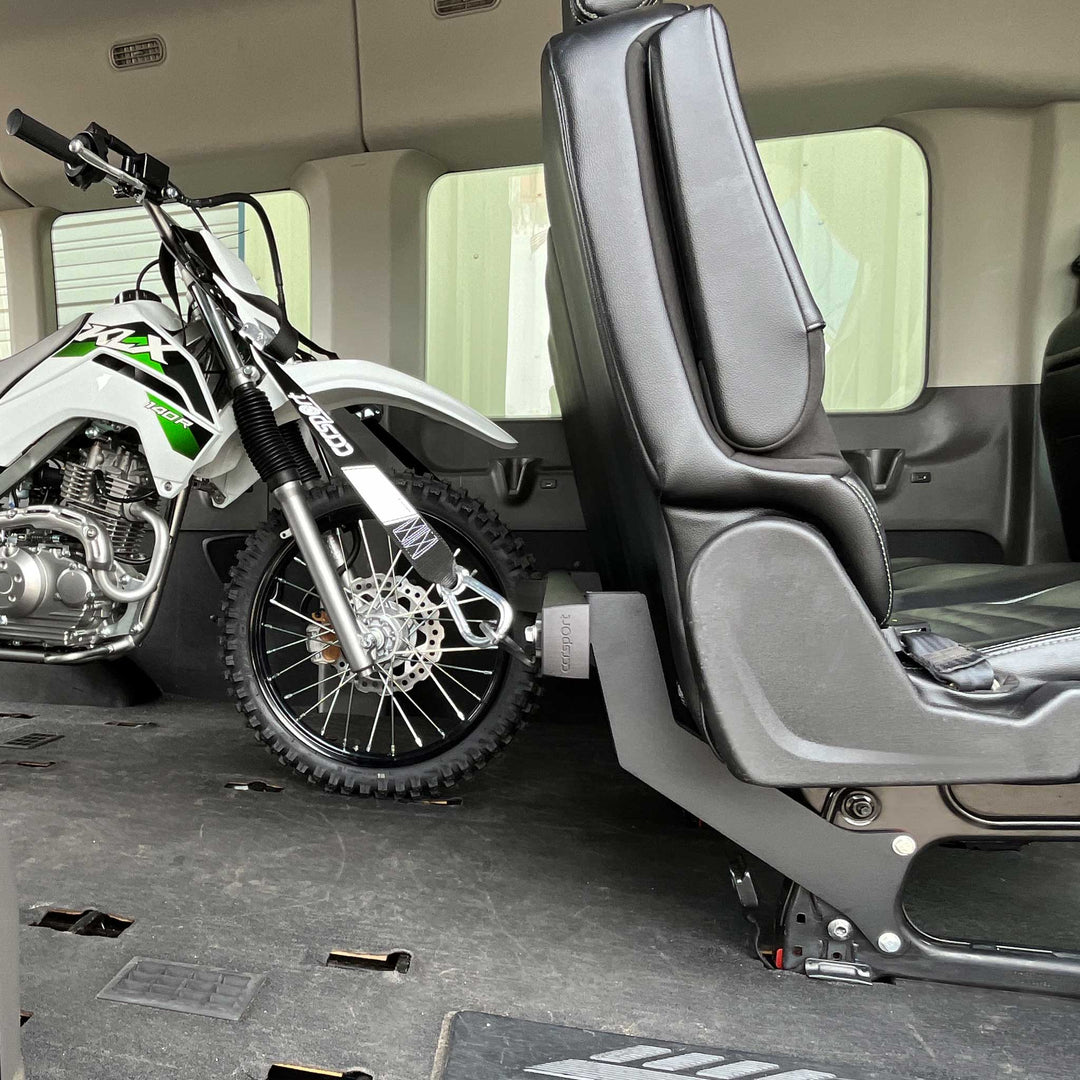 Side view of a Kawsaki KLX 140R secured to the Hybrid Moto Van Rack in a Mercedes Sprinter van,