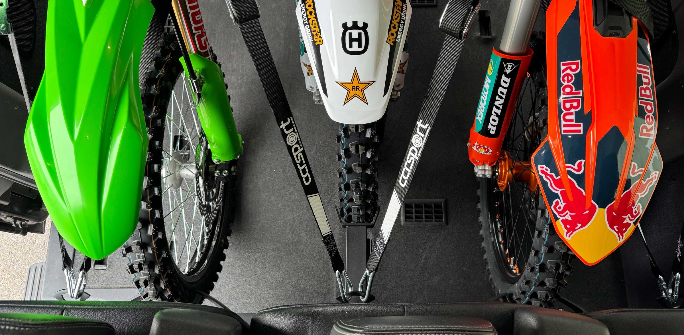 A top down view of three motorcycles strapped down to the seat base mounted Hybrid Moto Van Rack.
