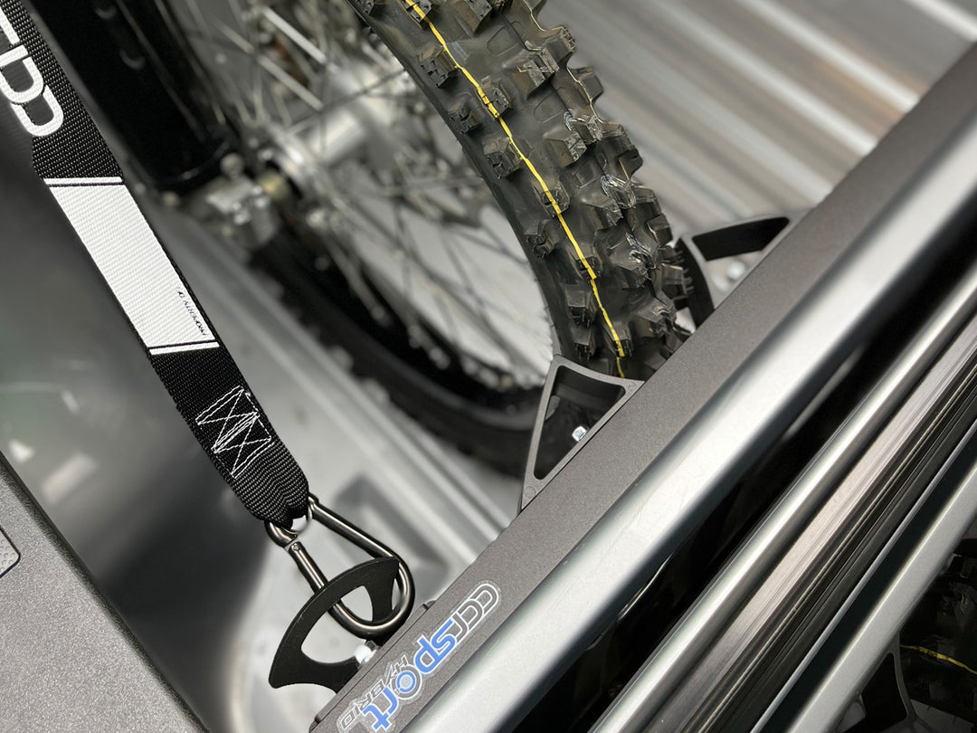A knobby motorcycle tire secured in a truck bed wheel chock.
