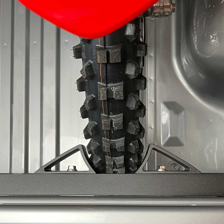 A straight down top view with a motocross motorcycle tire secured tight in the vise style wheel chock.