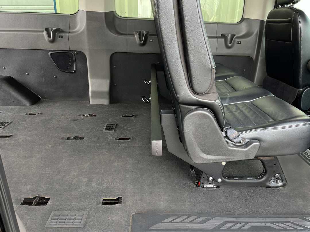 Side view of a black cargo rack mounted to the rear passenger seat of a for Transit van.