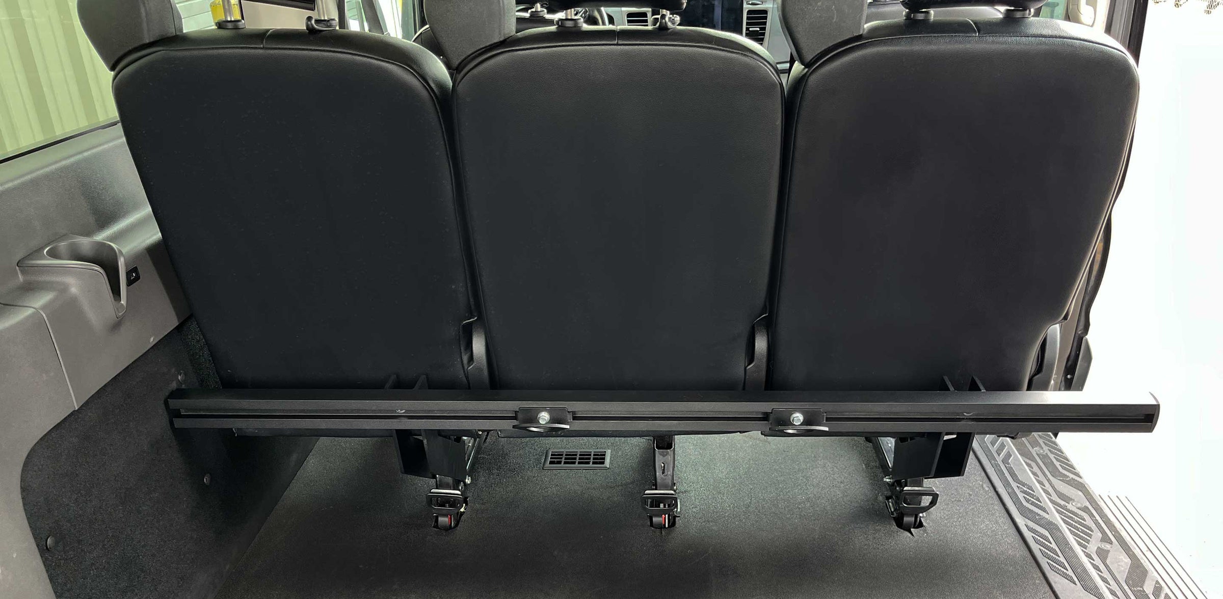 A rear forward facing view of a cargo rack attached to the rear passenger seat of a van.
