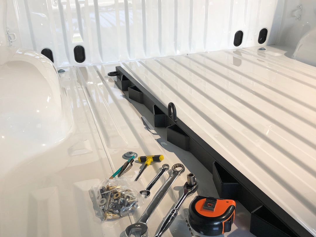 A Bed Buddy Moto Rack and installation tools in the bed of a truck awaiting installation.