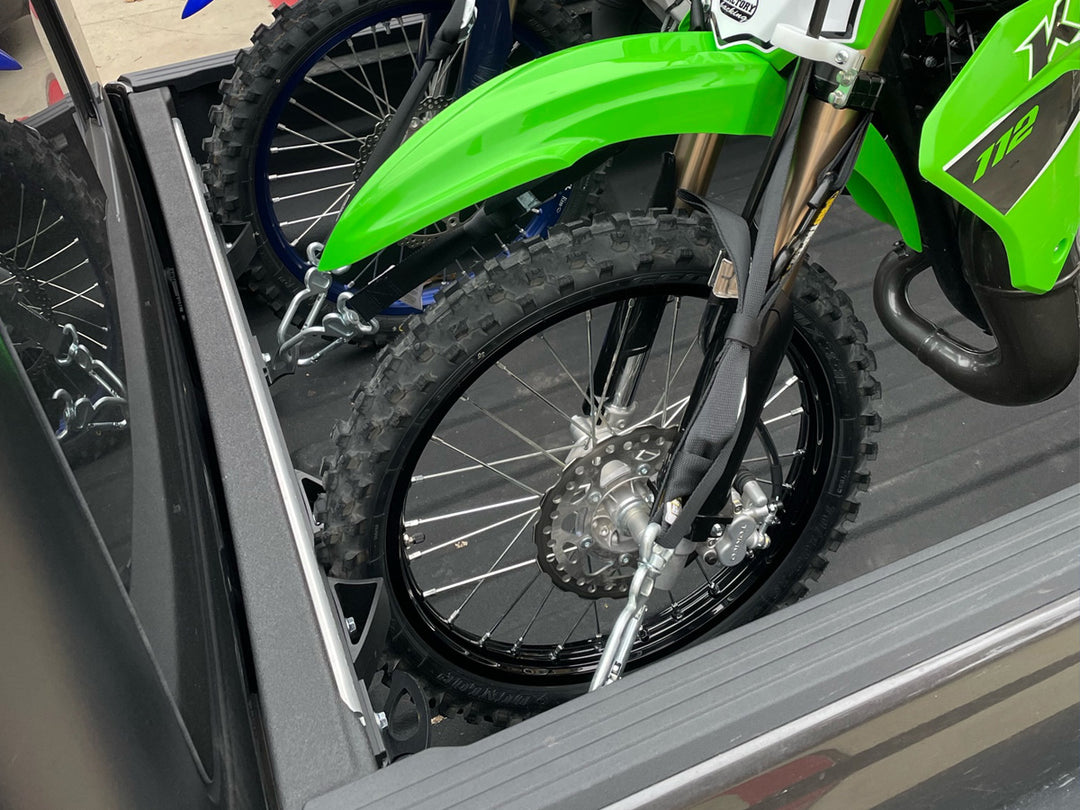 Off-road motorcycles secured in a Jeep Gladiator truck bed using a CCR Sport motorcycle transport system.