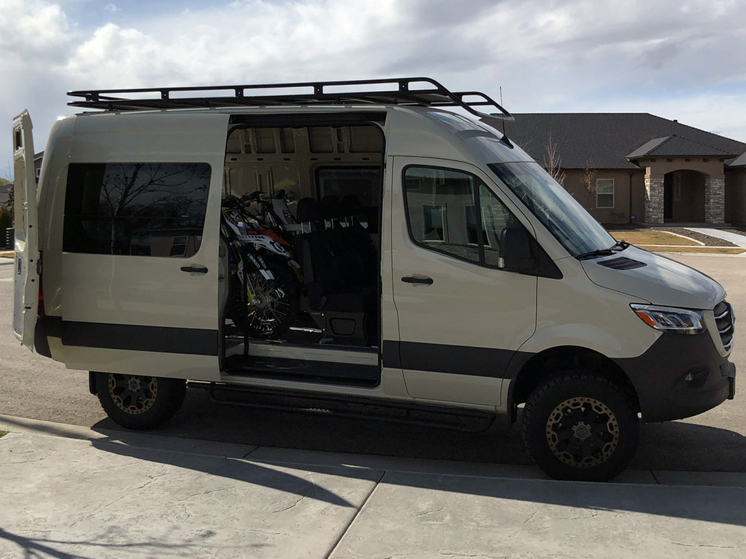 Off-road motorcycles secured inside a Mercedes Sprinter van using a CCR Sport motorcycle transport system.