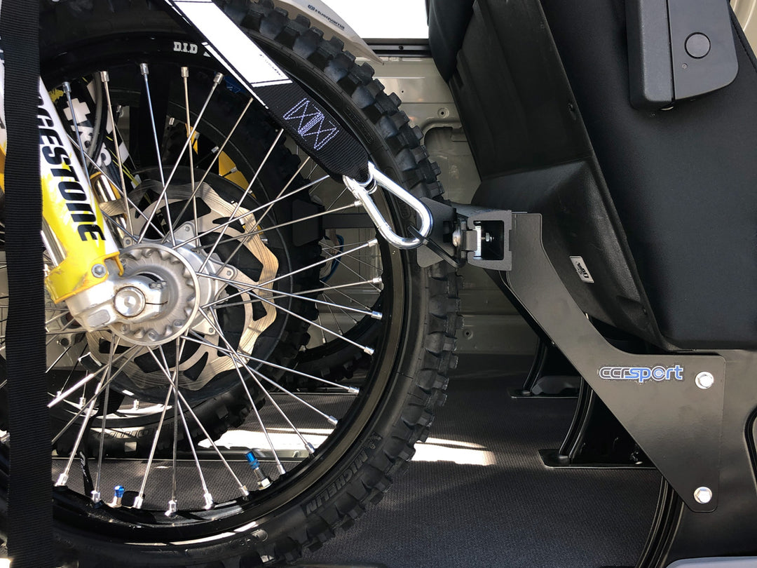 Front wheel of a dirt bike secured inside a Mercedes Sprinter van using a CCR Sport motorcycle transport restraint system.