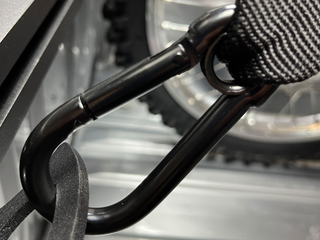 Close-up of the tie down strap carabiner attached to the anchor in a truck.