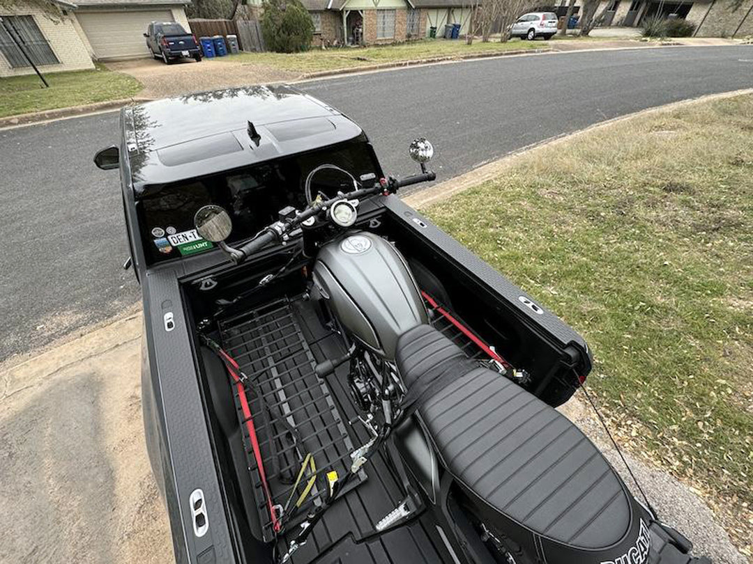 The Hybrid Moto Rack installed in a Rivian truck with a Ducati street bike loaded for transport.