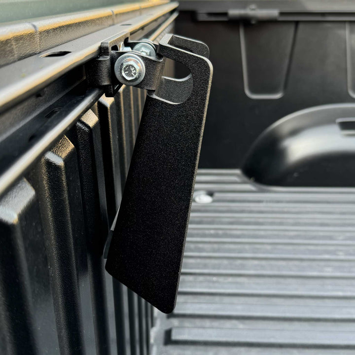 Close-up of Toyota Deck Rail Pivot Chock attached to deck rail with fastener hardware.