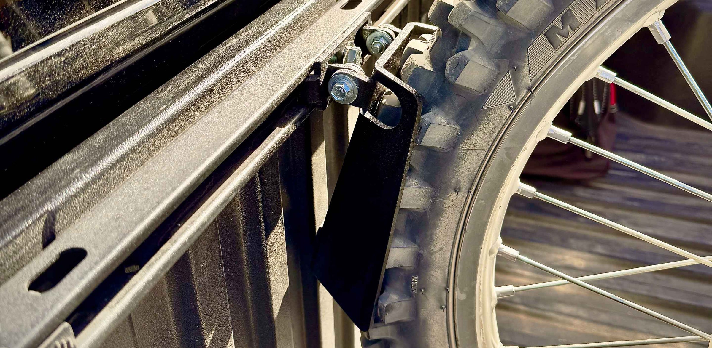 A motorcycle wheel chock holding a dirt bike tire in position.