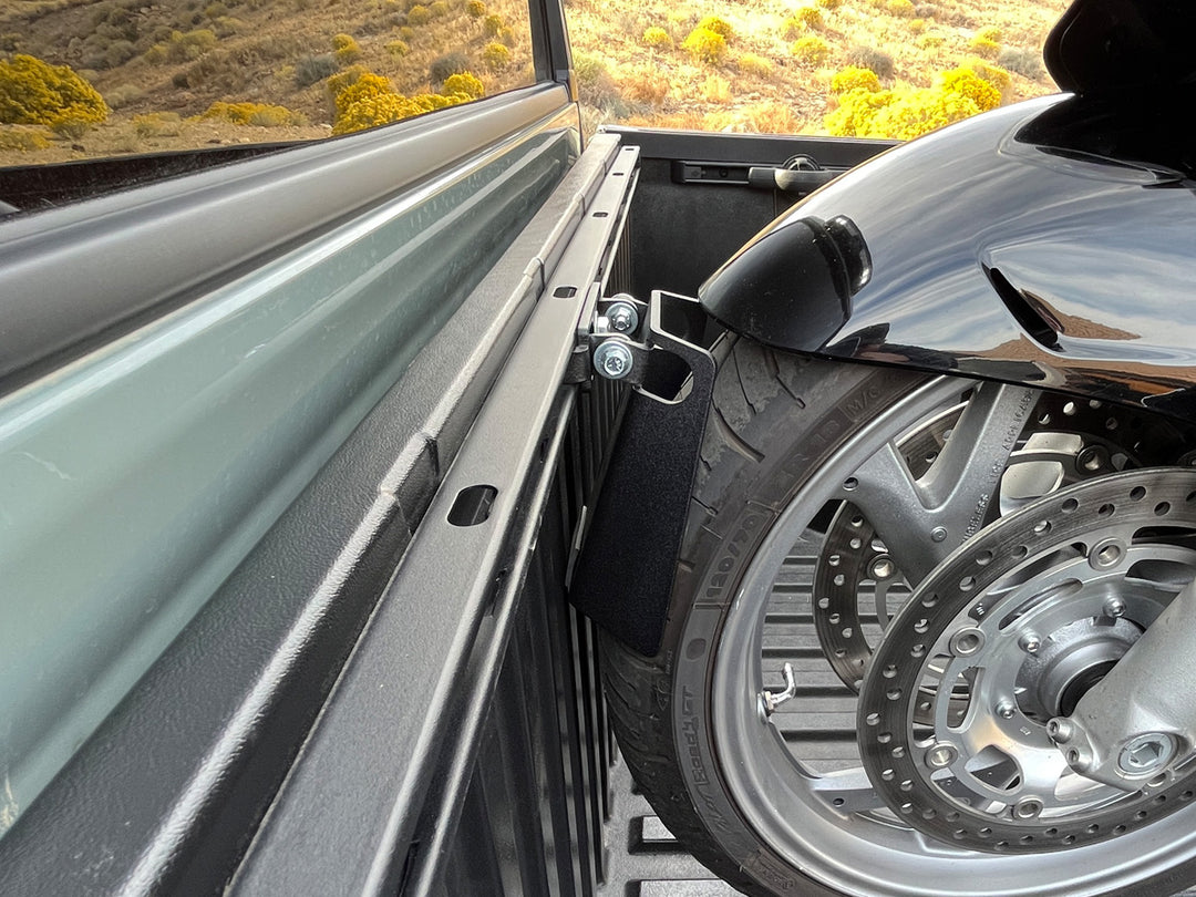 The Toyota Pivot Chock supporting the front wheel of a cruiser motorcycle in the bed of a Tundra.
