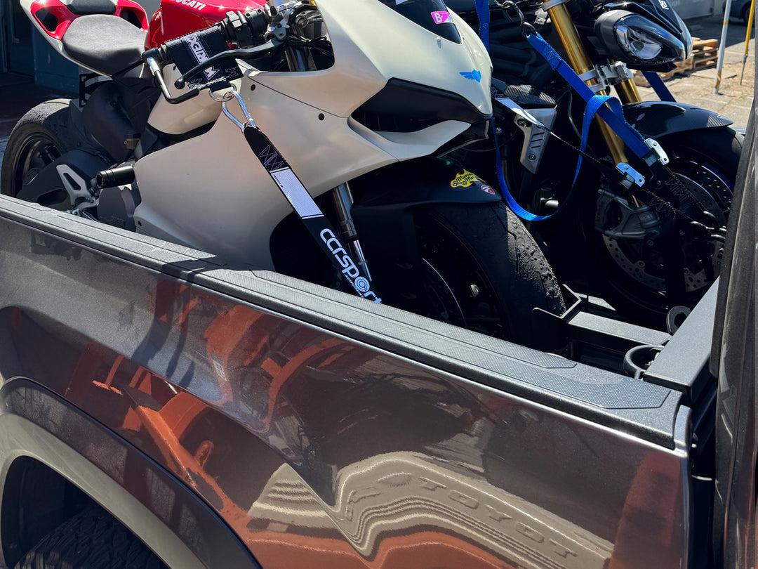 The Hybrid Offset Wheel Chock featured in a Toyota Tacoma holding a sport bike in position.