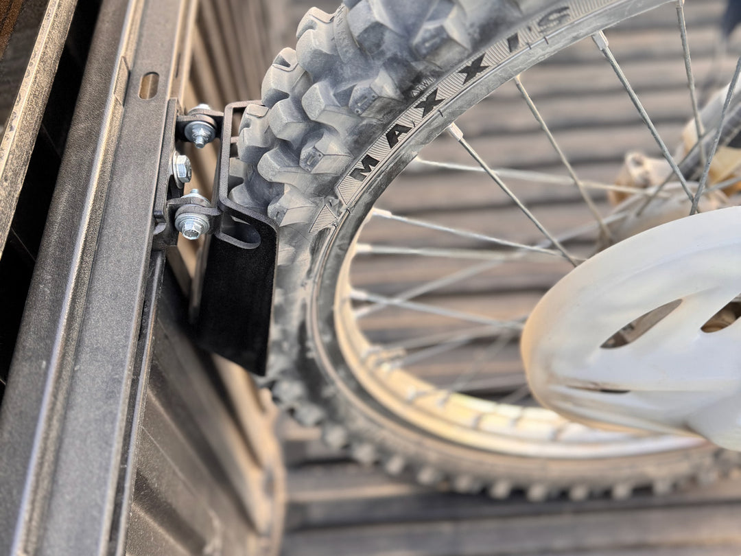 A close-up top down angle of a dirt bike stabilized in the Toyota truck using the CCR Sport Pivot wheel chock.