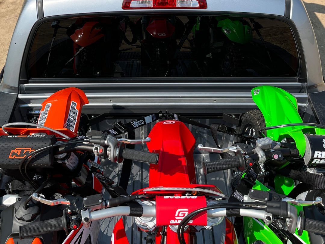 Three dirt bikes loaded in the bed of a truck with the CCR Sport Hybrid Moto Rack.