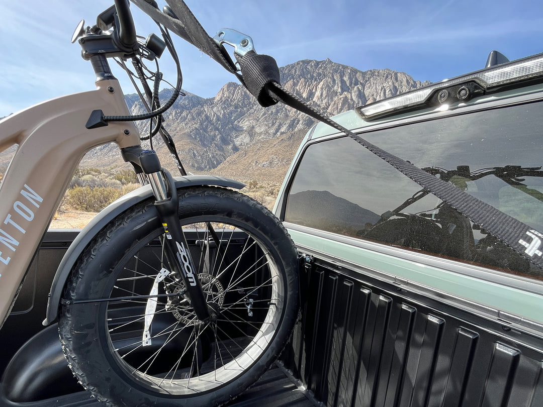 A fat tire ebike in the bed of a Toyota Tundra stabilized with the Pivot Chock with a scenic mountain back drop.