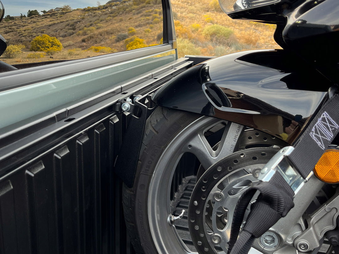 A close-up of a Honda touring motorcycle secured to the Toyota Deck Rail system with the CCR Sport Pivot motorcycle wheel chock.
