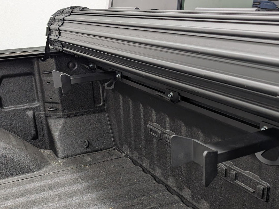 Offset wheel chocks shown mounted to the Hybrid Moto Rack in a truck with a roll-up bed cover.